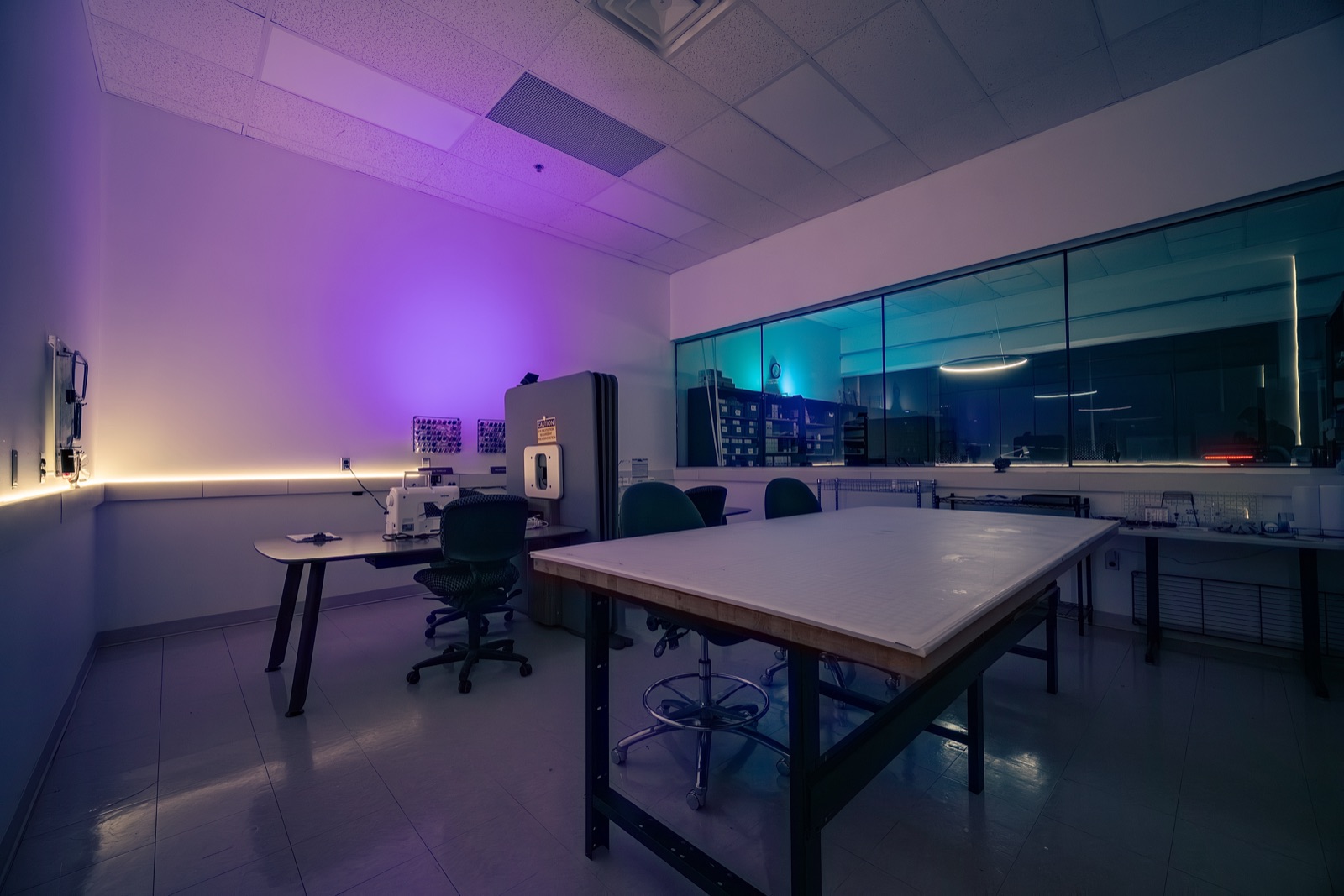 Sewing and embroidery machines under purple light