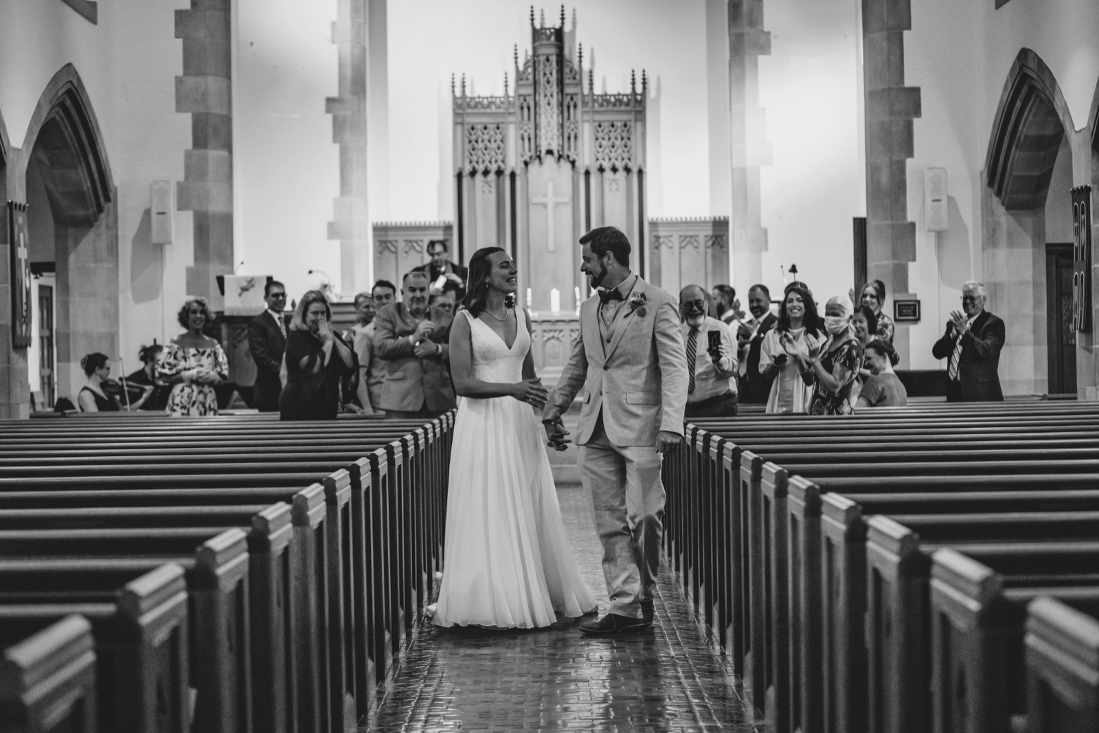 Bride and groom at the altar seen down the church aisle