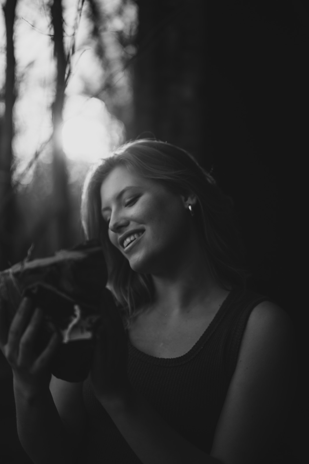 Black and white portrait of a woman holding a camera