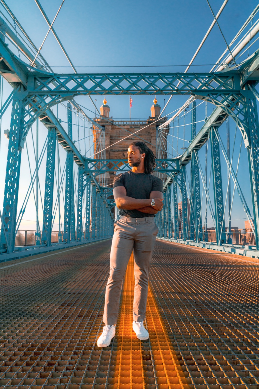 Man standing on a blue steel bridge