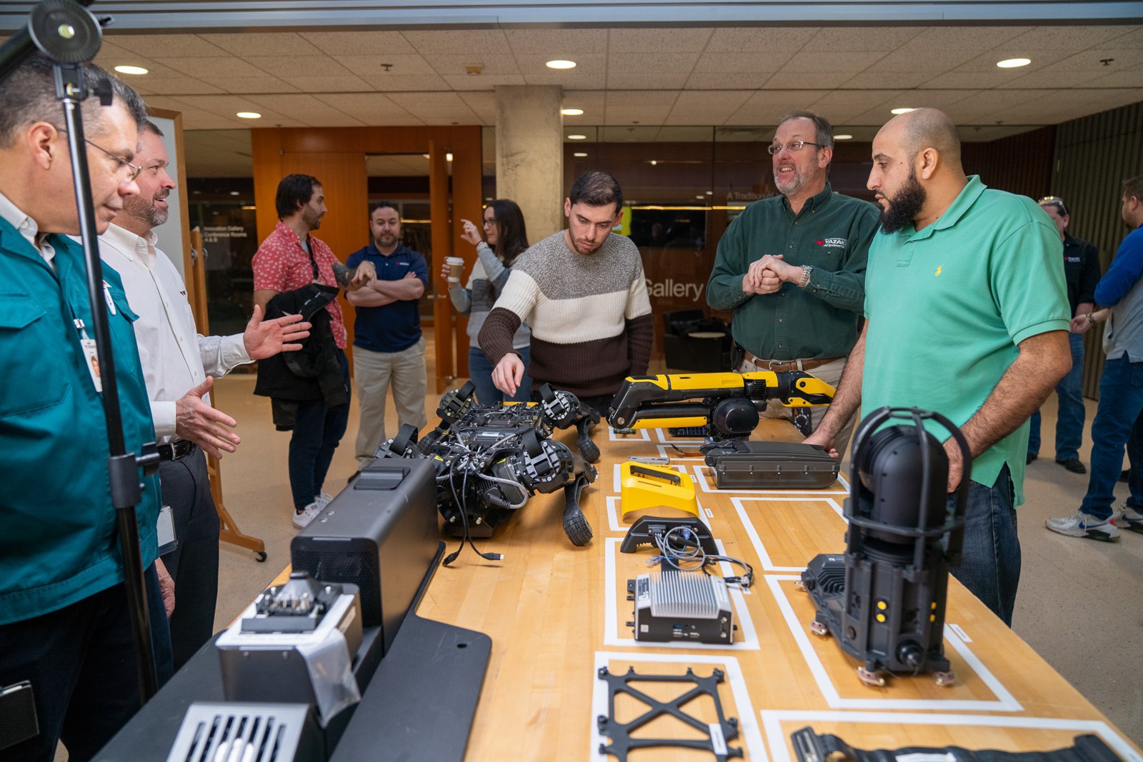 Engineers around a table of Spot robot parts